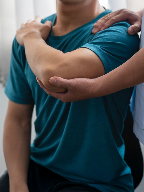 Therapeutische Behandlung von Schulter und Arm bei einer manuellen Therapie im Sitzen